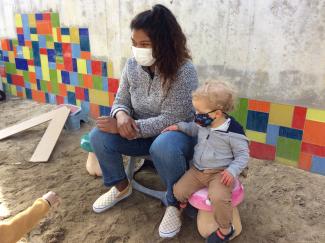 Teacher and Child sitting in sandbox