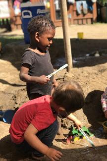 Toddlers playing in mud